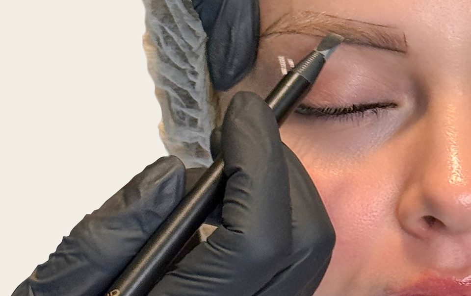 Le tracé du sourcil au crayon, main gantée au plus près